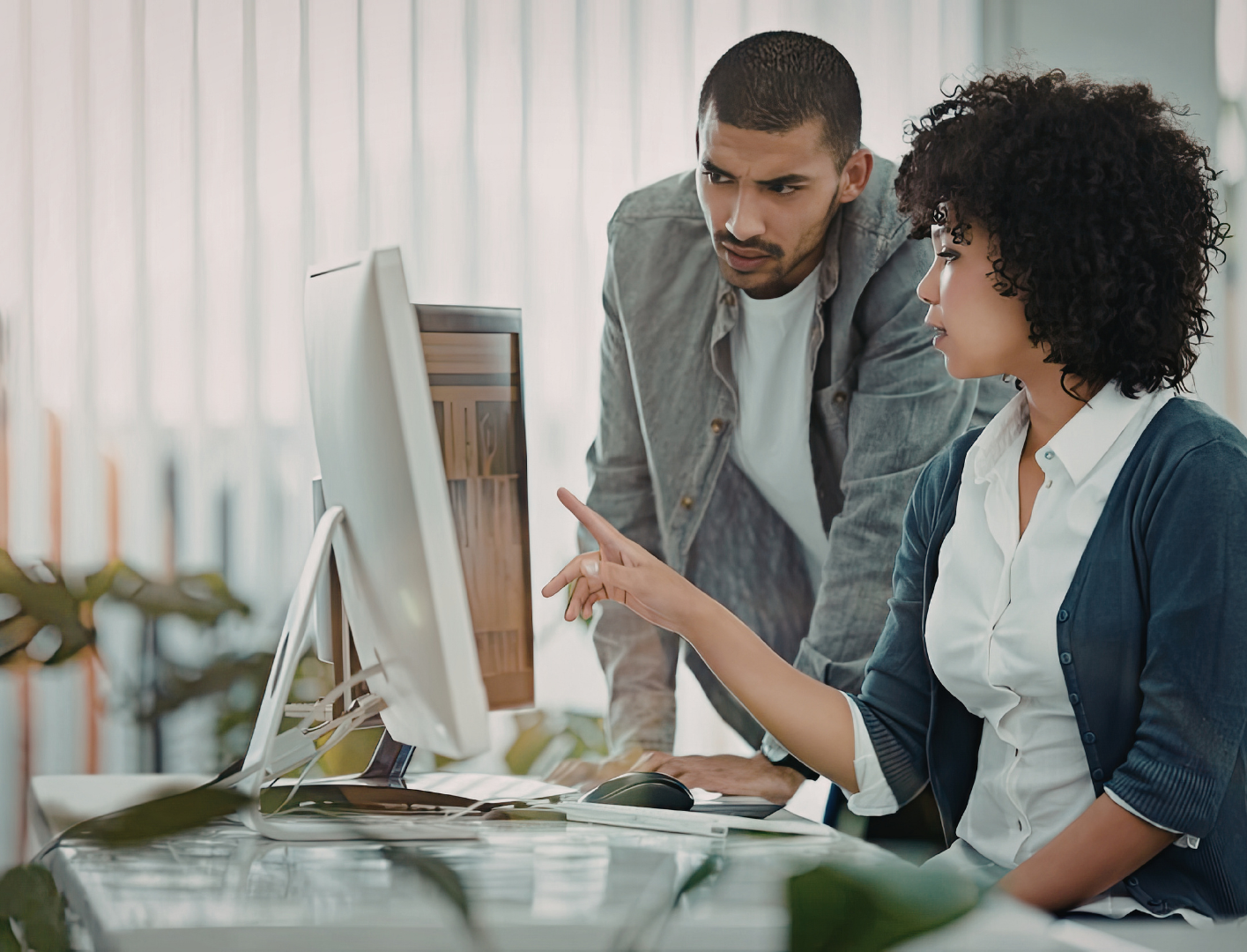 Une équipe en réunion hybride utilise un écran Lenovo pour une visioconférence, combinant présentiel et distanciel dans un environnement professionnel moderne.